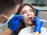 A dentist performing a root canal on a young woman