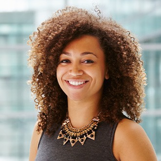 Smiling woman wearing gray sleeveless blouse