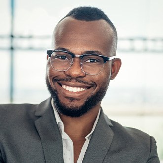 Young man grinning in gray business jacket