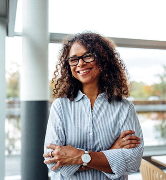 Portrait of woman with curly hair smiling in office