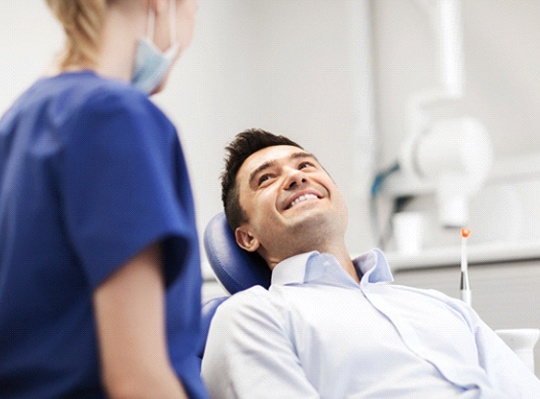 Man smiling while talking to Parma Heights dentist