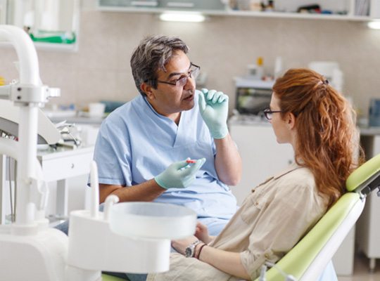 a patient speaking with her emergency dentist in Parma Heights