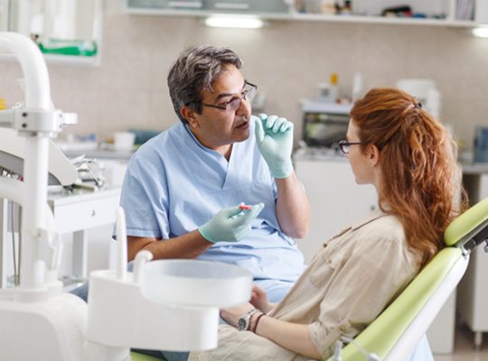 a patient speaking with her emergency dentist in Parma Heights