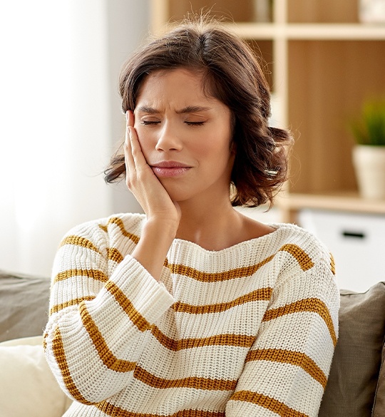 Woman in pain holding cheek