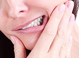 Man holding cheek in pain