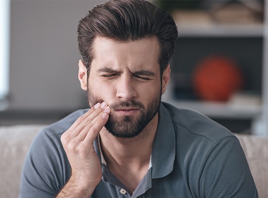 Man in pain holding jaw