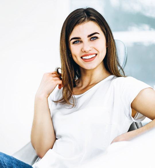 Smiling patient in dental office with dental implants in Parma, OH