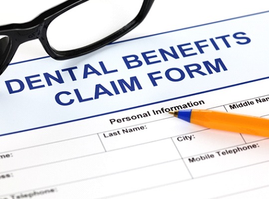 Dental benefits claim form with glasses and pen