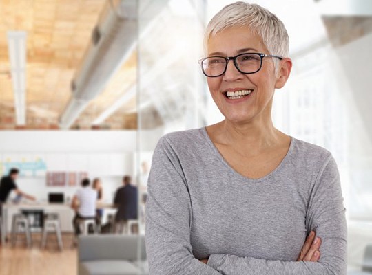 senior woman crossing her arms while smiling and looking off into the distance 