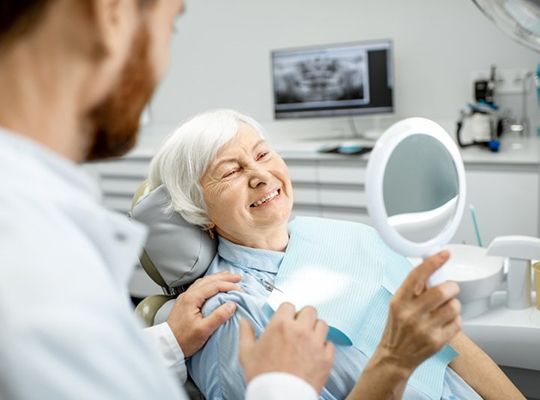 a patient smiling after receiving dental implants