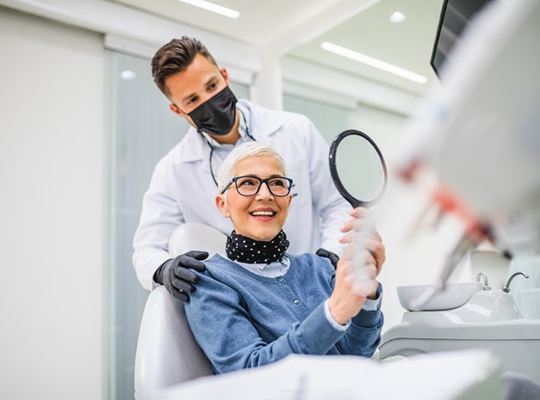 a patient checking their smile after replacing missing teeth