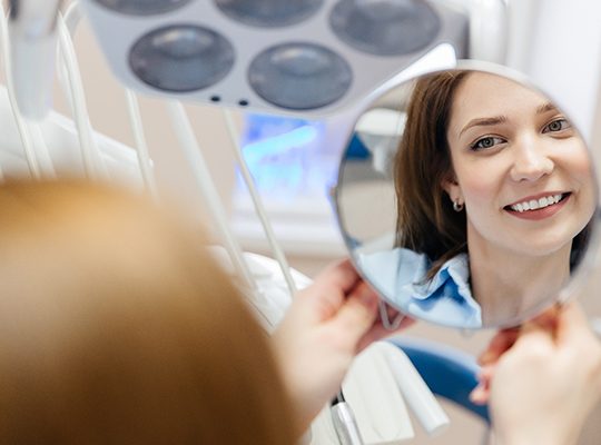 A woman smiling at her dental implants