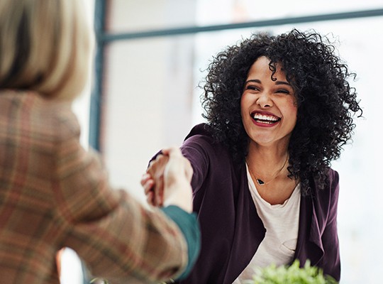 Smiling woman shaking colleague's hand