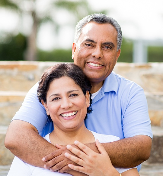 Older man and woman smiling outdoors