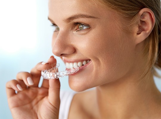 Woman placing Invisalign tray