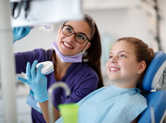 Dentist and child looking at chairside computer monitor