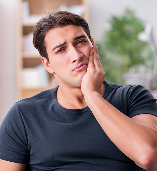 Man in pain holding cheek