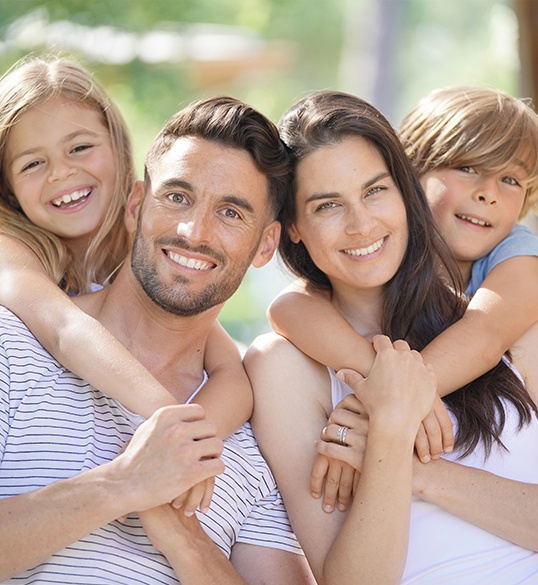 Smiling family of four outdoors