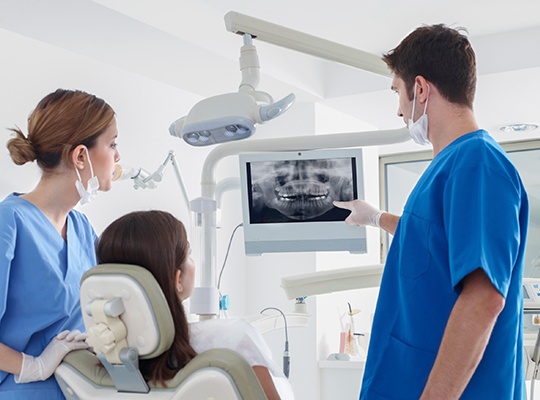 Dentist and patient looking at digital x-rays