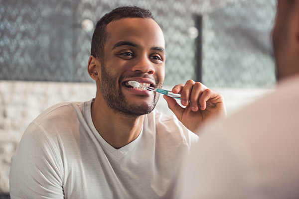 person brushing teeth in mirror