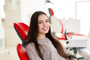 Female dental patient sitting in chair smiling